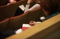 Woman writing in notebook at Narrative Medicine workshop.